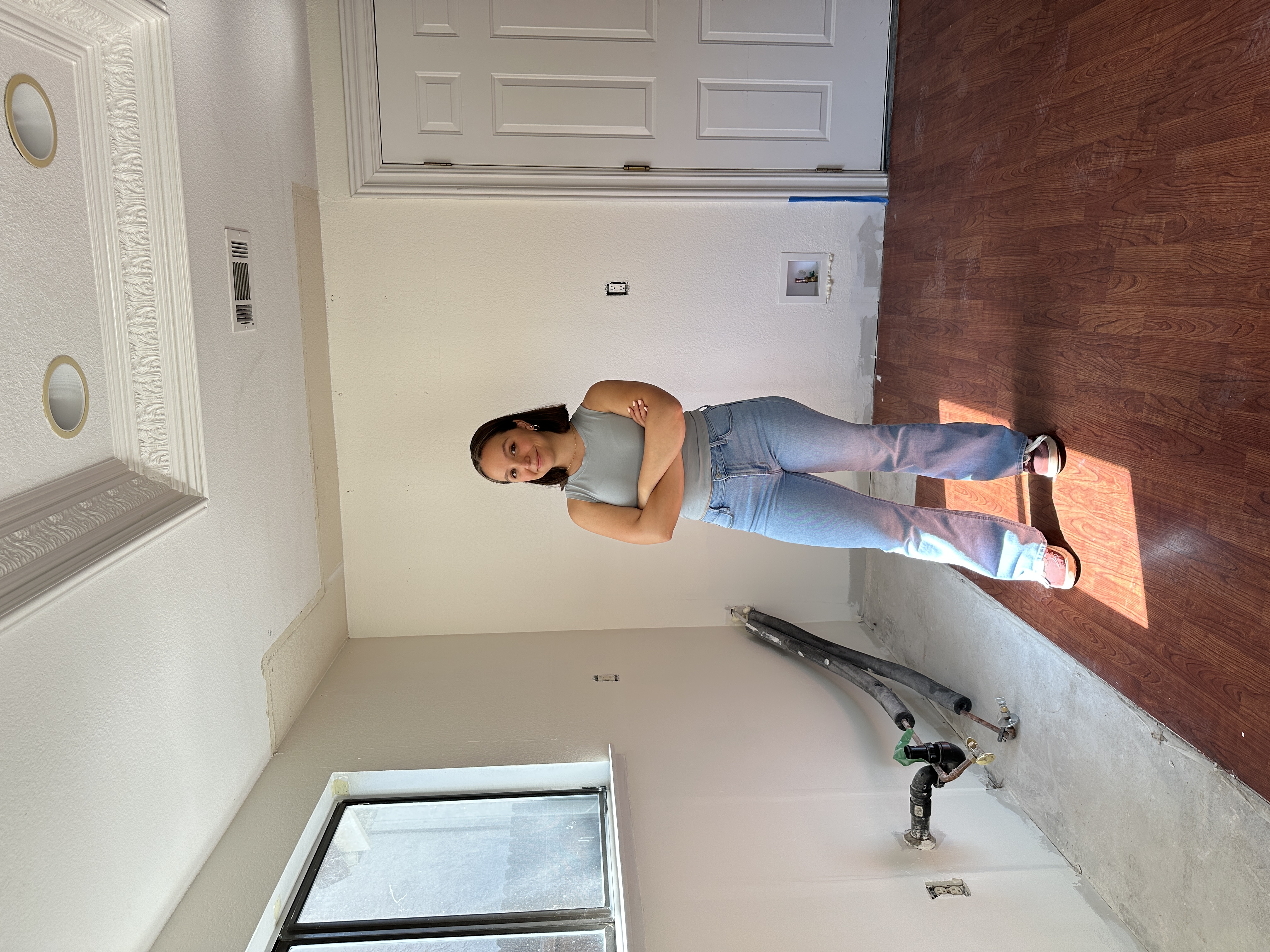 Person standing in a newly prepped kitchen space in Antioch, CA, with freshly painted walls post-demolition.