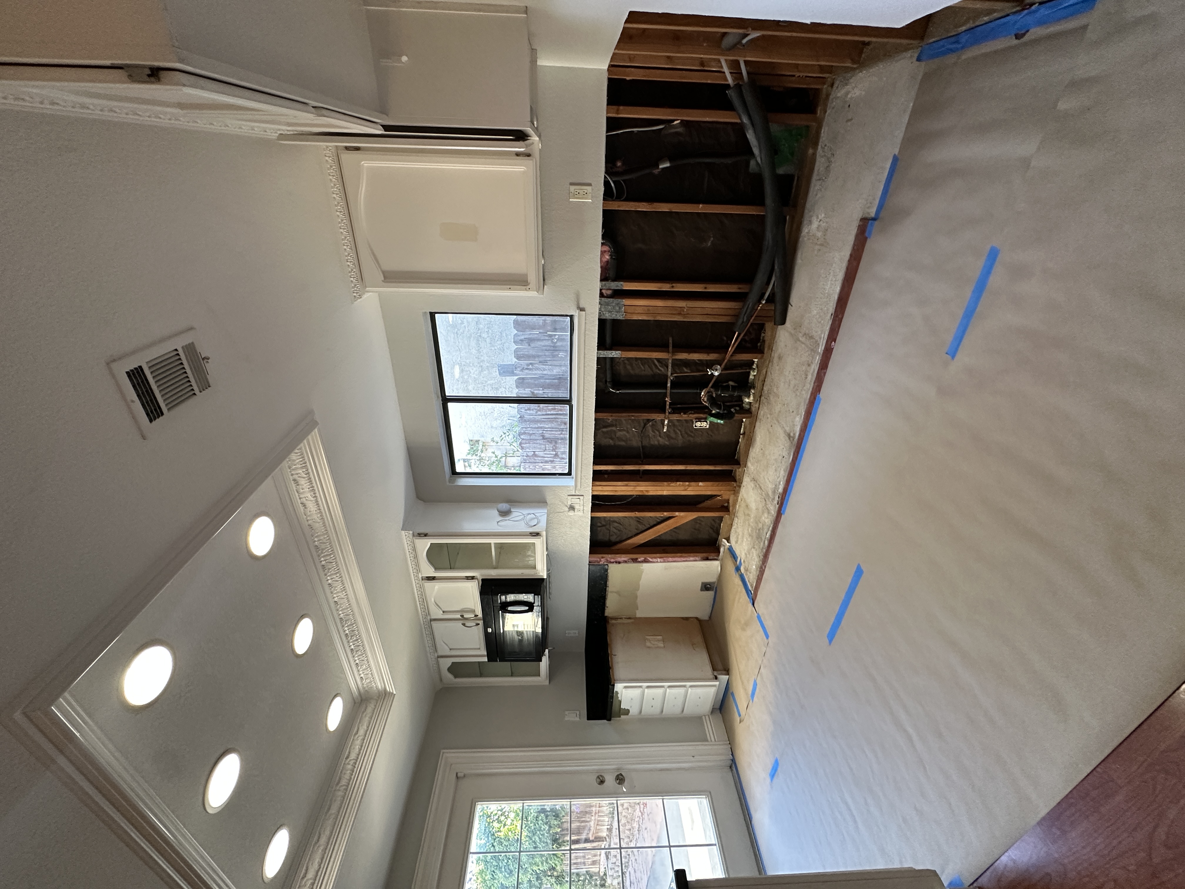 Kitchen interior during renovation in Antioch, CA, showing exposed wall studs where lower cabinets were removed due to mold.