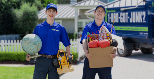 Two 1-800-GOT-JUNK? team members carrying donation items away from junk removal