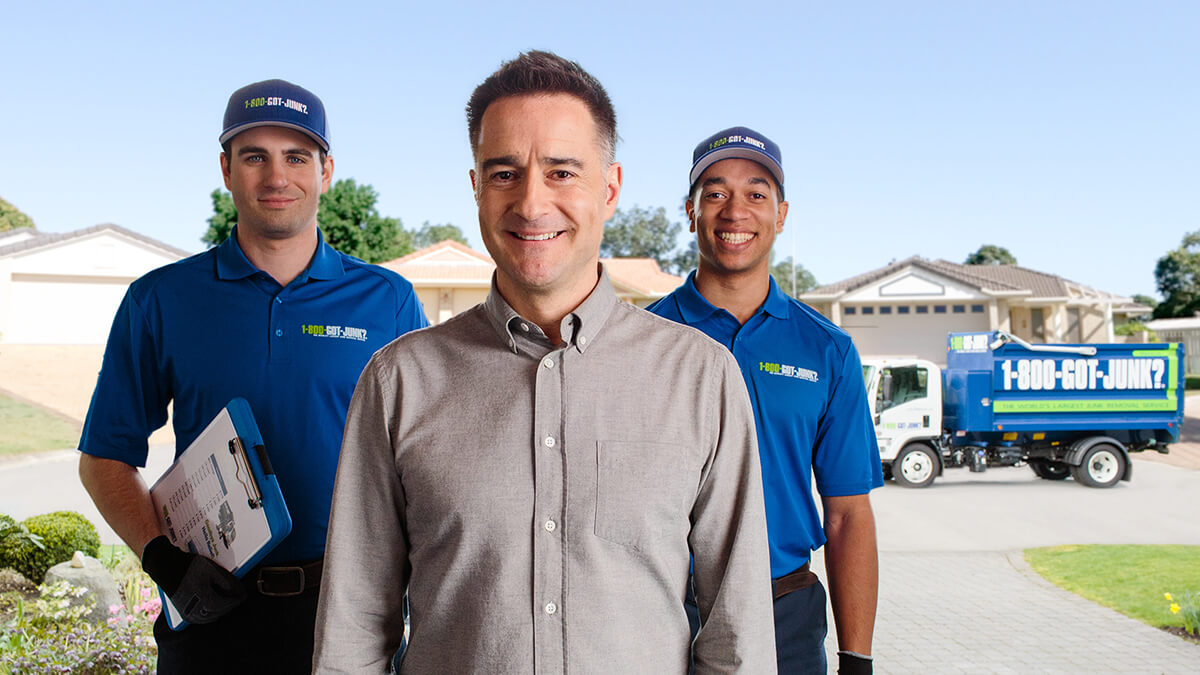 1-800-GOT-JUNK? Founder, Brian Scudamore and two Truck Team Members smiling in front of a home.
