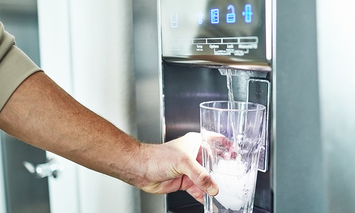 A close-up of a refrigerator water filter installed in a fridge with a water filtration system.