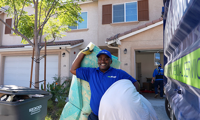 A 1-800-GOT-JUNK? Truck Team Member removing junk from a customer's home.