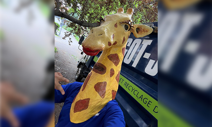 A 1-800-GOT-JUNK? Truck Team Member in a Giraffe Head