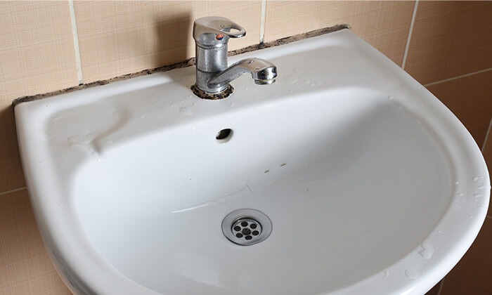 An old bathroom sink ready to be disposed.